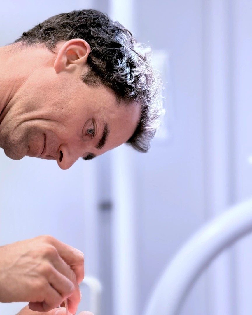 Dr. Dr. Marc Füßinger lächelt während der Arbeit