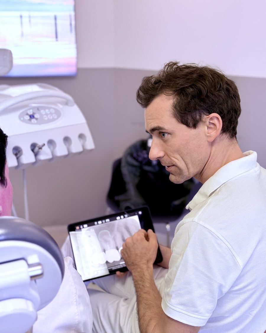 Dr. Dr. Marc Füßinger bespricht eine Aufnahme auf dem Tablet