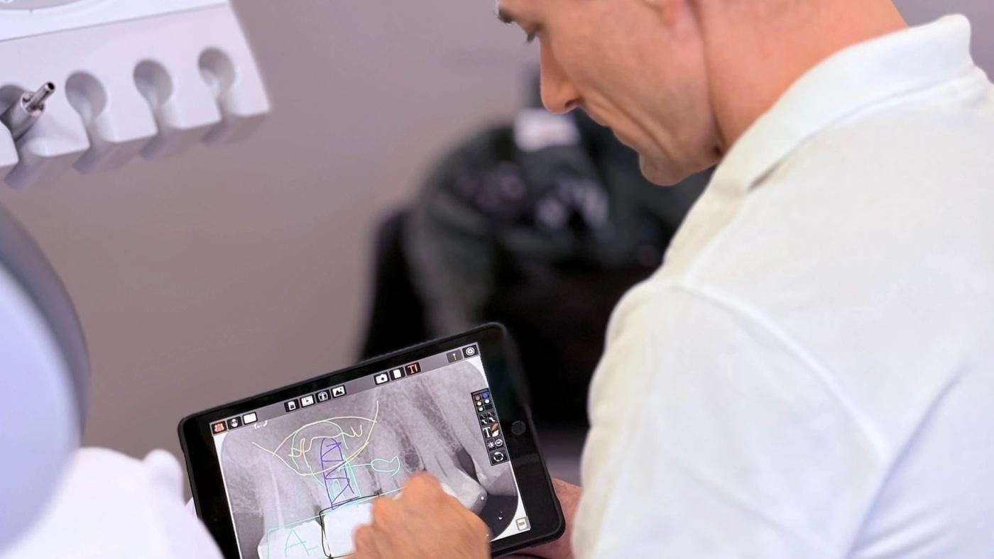 Dr. Dr. Marc Füßinger bespricht eine Aufnahme auf dem Tablet