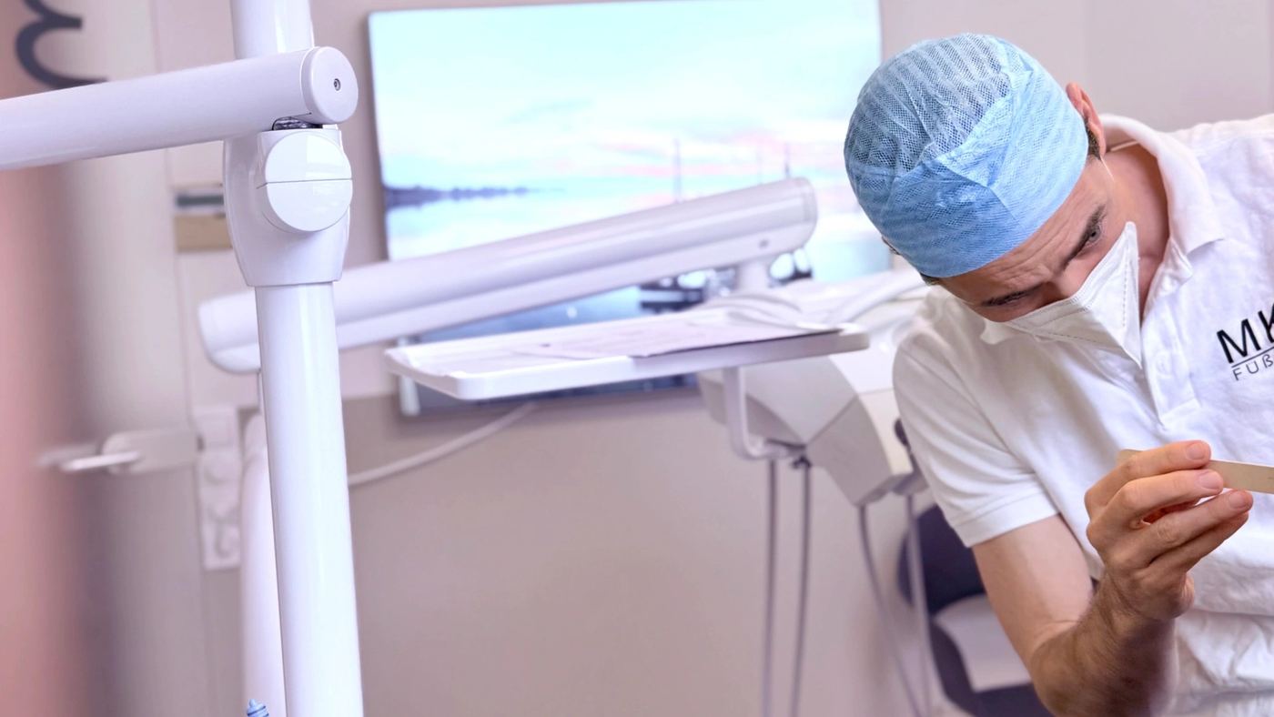 Dr. Dr. Marc Füßinger bei einer Nachkontrolle im Behandlungsraum mit Seebild
